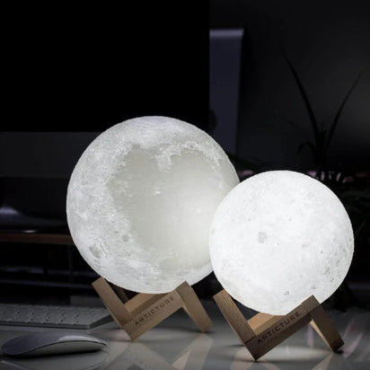 Two moon-shaped lamps on stands with a dark background