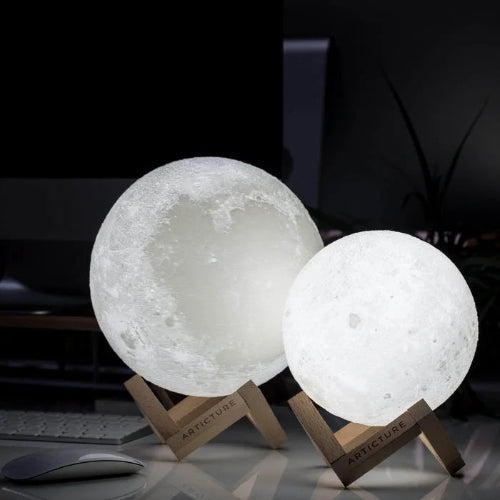Two moon-shaped lamps on stands with a dark background