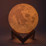 Moon-shaped lamp on a stand with a dark background