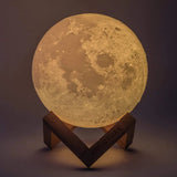 Moon-shaped lamp on a wooden stand with a dark background