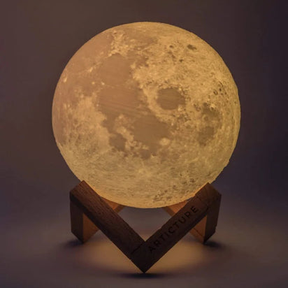 Moon-shaped lamp on a wooden stand with a dark background